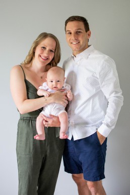 Jami smiles with her husband and infant son