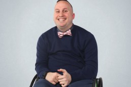 Smiling man in wheelchair with bowtie.