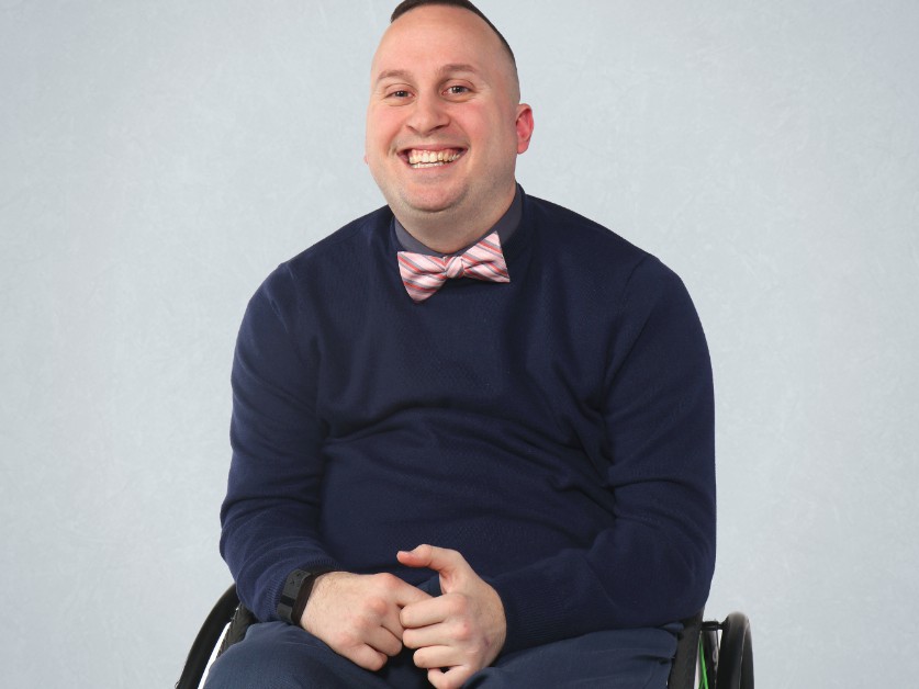 Smiling man in wheelchair with bowtie.