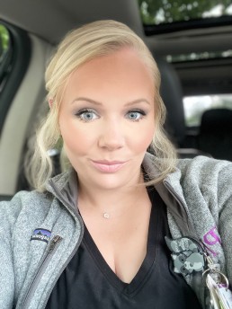 Smiling blonde woman in nursing scrubs