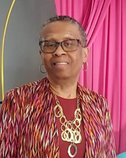 Headshot of older woman in a colorful shirt.